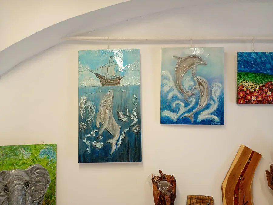 Quadri dipinti a tema marino appesi a una parete